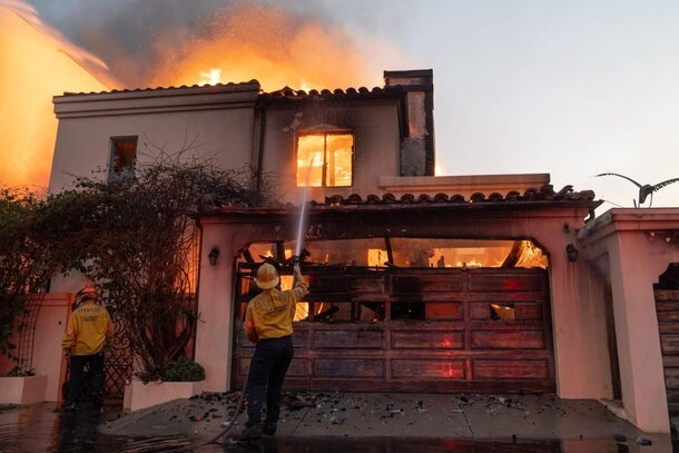 Firefighters attempt to extinguish a fire in a home along the Pacific Coast Highway in the Pacific Palisades neighborhood on Jan. 8, 2025.